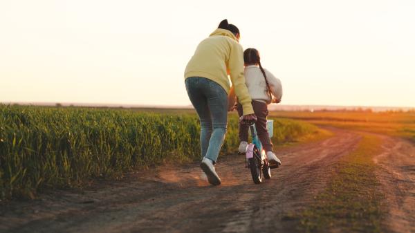 Mother pushing child on bike